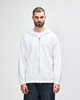 A white full zip hooded sweatshirt on a model, featuring a front pocket and a drawstring hood.