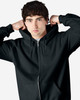A black full zip hooded sweatshirt worn by a young man, featuring a logo on the front.