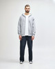 A grey full zip hooded sweatshirt featuring a front pocket and a hood. It has a logo on the side.