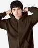 A brown Gildan Heavy Blend adult full zip hooded sweatshirt, featuring a front zipper and a model adjusting the hood.