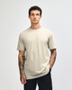 A unisex short sleeve T-shirt in a neutral beige colour, displayed on a model. It features a simple design and logo.