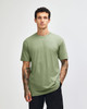 A plain green unisex CVC short sleeve T-shirt displayed on a model, featuring a subtle logo.