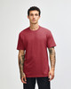 A unisex CVC short sleeve T-shirt in a rich burgundy colour, displayed on a model. Features a logo.