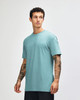 A teal unisex CVC short sleeve t-shirt displayed on a model, featuring a simple design and relaxed fit.