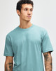A unisex short sleeve t-shirt in a soft turquoise colour, featuring a logo on one side.