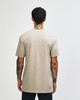 A unisex short sleeve T-shirt in a muted beige colour with a plain back view. The shirt has a branding logo.