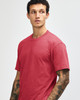 A unisex short sleeve T-shirt in a warm red colour, displayed on a model with a simple design and logo.