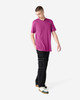 A unisex short sleeve T-shirt in vibrant pink, paired with relaxed black pants and a casual stance.