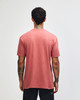A unisex CVC short sleeve t-shirt in a dusty pink colour, featuring a logo on the back.