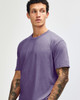 A unisex short sleeve t-shirt in a purple hue, featuring a simple design and a logo.