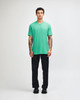 A unisex short sleeve t-shirt in vibrant green, paired with black cargo pants and styled on a male model.