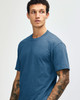 A unisex short sleeve t-shirt in a deep blue colour, featuring a simple design and a subtle logo.