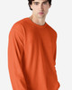 An orange long sleeve T-shirt on a model, featuring a simple design and a logo on the shirt.
