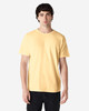 A model wearing a yellow Gildan Heavy Cotton adult T-shirt, paired with blue jeans. The shirt has a logo.