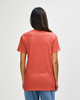 A person wearing a coral Gildan Heavy Cotton Adult T-shirt, viewed from the back, showcasing its simple design.