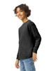 A youth long sleeve t-shirt in black, featuring a logo, worn by a smiling child.