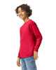 A youth long sleeve t-shirt in bright red, featuring a logo, displayed on a young person smiling.