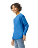 A blue long sleeve youth T-shirt with a round neck and a logo on the side, modelled by a smiling child.