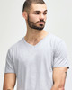 A grey Gildan Softstyle adult v-neck t-shirt displayed on a model with short hair and a beard.