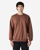 A brown Gildan Softstyle adult sweatshirt displayed on a model, featuring a classic crew neck and long sleeves.