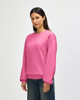 A pink Gildan Softstyle adult sweatshirt displayed on a model, featuring long sleeves and a crew neckline.