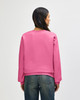 A pink Gildan Softstyle adult sweatshirt seen from the back, paired with blue jeans. The sweatshirt has a logo.