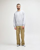 A grey Gildan Softstyle adult sweatshirt worn by a man, paired with khaki trousers and black shoes, standing on a plain background.