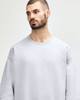 A grey Gildan Softstyle adult sweatshirt with long sleeves and a relaxed fit, featuring a subtle logo.