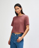 A model wears a dusty rose American Apparel women's fine jersey boxy T-shirt, featuring a relaxed fit and short sleeves.
