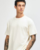 A unisex heavyweight cotton T-shirt in cream, featuring a relaxed fit and a subtle branding logo.