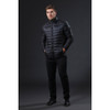 A stylish black puffer jacket displayed on a model standing against a dark background, featuring a logo on the chest.