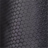 A close-up of a textured black fabric featuring a hexagonal pattern. The fabric appears durable and supportive.