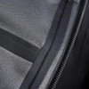 A close-up of a black softshell jacket, showcasing its fabric texture and zipper detail. It features a logo on the fabric.