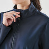 A navy softshell jacket with a high collar and zip closure, featuring a logo on the upper section.