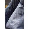 A close-up of a blue and white striped button-up shirt, featuring a folded collar and textured fabric.