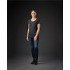 A woman stands in a fitted black and grey striped crew neck t-shirt, paired with dark jeans and ankle boots.