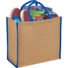 A large jute tote in natural and blue, filled with shoes, a drink bottle, and clothing items.