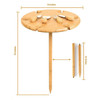 A bamboo outdoor party table features a round top with cut-out shapes, a wooden base, and includes utensils.