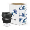A drink bottle with a clear cup and black silicone sleeve, packaged in a decorative box featuring floral designs.