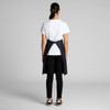 A person wearing a black Carrie Half Apron over a white T-shirt and black pants, facing away from the camera.