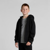 A young boy stands wearing a black Youth Relax Zip Hood hoodie over a grey t-shirt. The hoodie has a front zip and a hood.