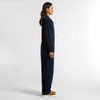A navy blue canvas coverall with a fitted style, featured from the side. The model stands against a plain background.