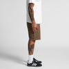 Canvas shorts in brown, featuring side pockets, worn with a white T-shirt and black sneakers.
