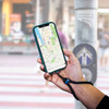 A hand holding a smartphone displaying a map, attached to a black eco-friendly wristband strap.