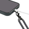 A phone with a black and white lanyard wristband eco strap connected to its charging port.