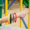 A wrist adorned with colorful silicone flyers, including red, orange, green, black, yellow, and blue discs. 