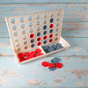 A Connect Four game set featuring a grid for gameplay, with red and gray game pieces in two separate compartments.