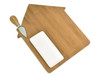 A bamboo cheese board shaped like a house, featuring a cheese knife and a white rectangular dish.