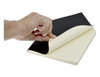 A black A5 notebook with lined pages, being opened, featuring a smooth cover and a hand holding it.