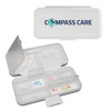 A white compact pill organizer with multiple compartments and a transparent lid, featuring a logo on top.